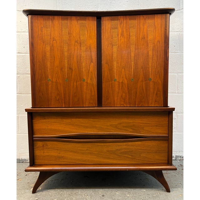 Add timeless style and exceptional craftsmanship to your home with this beautiful mid-century walnut highboy dresser....