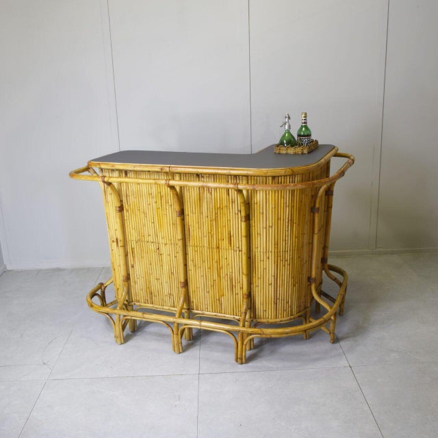 Tito Agnoli's elegant corner bar counter is crafted from solid bamboo and woven wicker. The supporting structure is made...