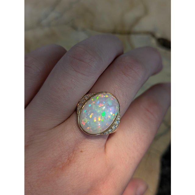 This striking ring showcases a 7.33-carat untreated Ethiopian opal, measuring 17.03 x 12.5mm, known for its vivid play-of-...