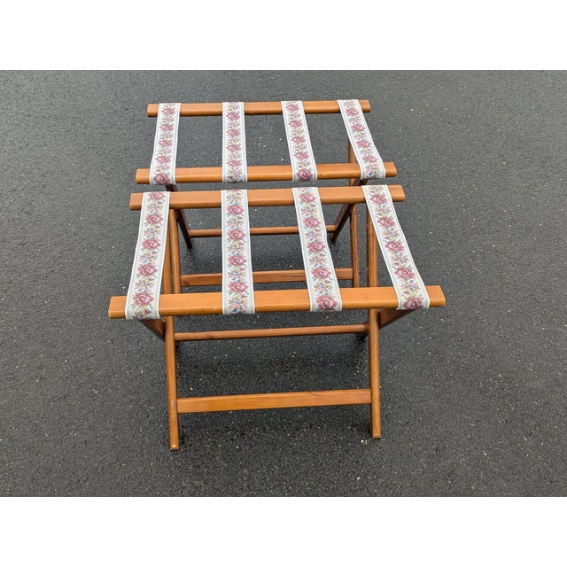 This pair of vintage folding luggage racks are composed of stained wood framing and stretchers and canvas strips. They...