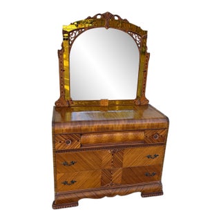 Vintage Art Deco Waterfall Dresser With an Attached Arched Mirror Featuring Amber-Tinted Glass Panels and Geometric Wood Inlay on Casters For Sale