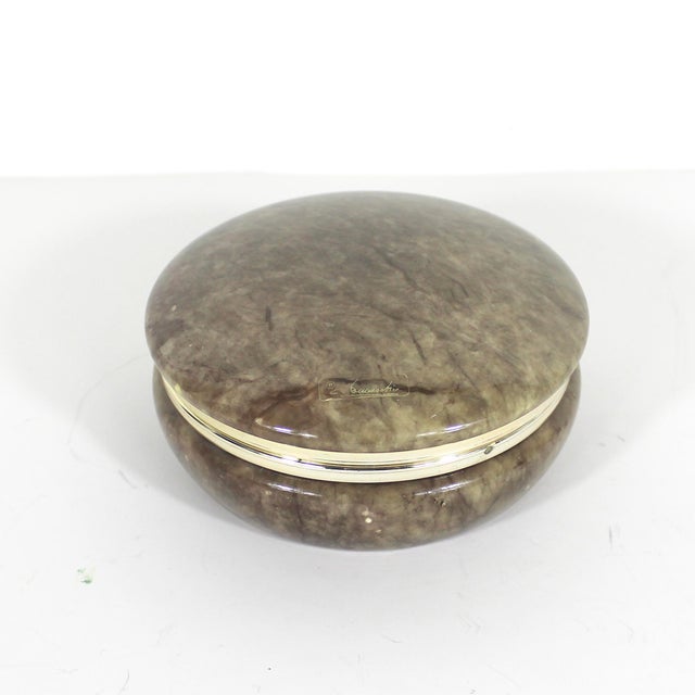 This is a beautiful hand carved Italian alabaster trinket box with a hinged lid. It is round and the metal trim is gold...