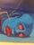 A surrealist composition featuring a vivid blue humanoid head fused with an insect‑like body. The figure’s exaggerated...