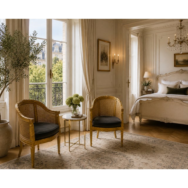 A beautiful pair of antique French giltwood bergere armchairs of elegant neoclassical form. These stylish chairs feature...