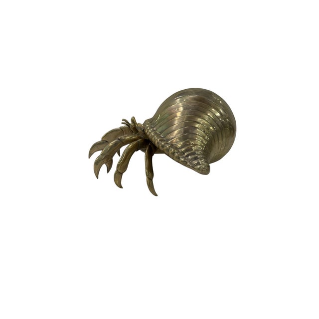 A beautifully cast bronze hermit crab sculpture, distinguished by its bold ribbed shell and finely articulated form. The...