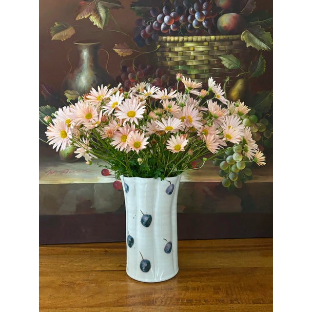 Very unique tall scalloped pottery vase painted simply with berries. Makes a great impression on display or filled with...