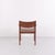 Armchair made of teak with seat and back upholstered in brown leather. The chair is representative of Danish furniture...
