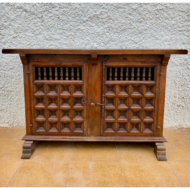 Elegant Spanish Renaissance Revival credenza crafted in solid wood, dating from the 20th century. The front features two...