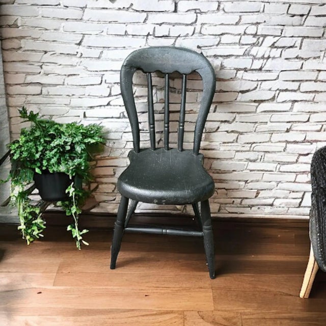 Offering an antique primitive black accent chair right out of the farmhouse. Rounded back with crest rail, accented by bow...