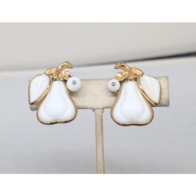 Goldtone white thermoset molded pear with single leaf and white bead clip earrings. Marked crown "TRIFARI DESIGN PAT....