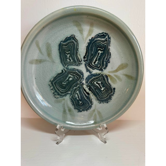 Meet your new favorite coastal conversation piece. This handmade ceramic plate features five beautifully marbled “faux...
