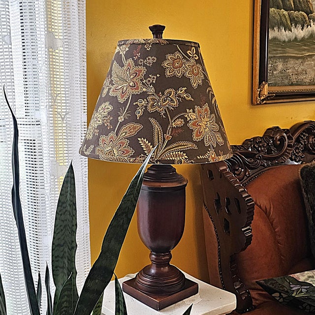 Vintage traditional table lamp featuring a turned wood urn-form base in a rich walnut finish paired with a coordinating...