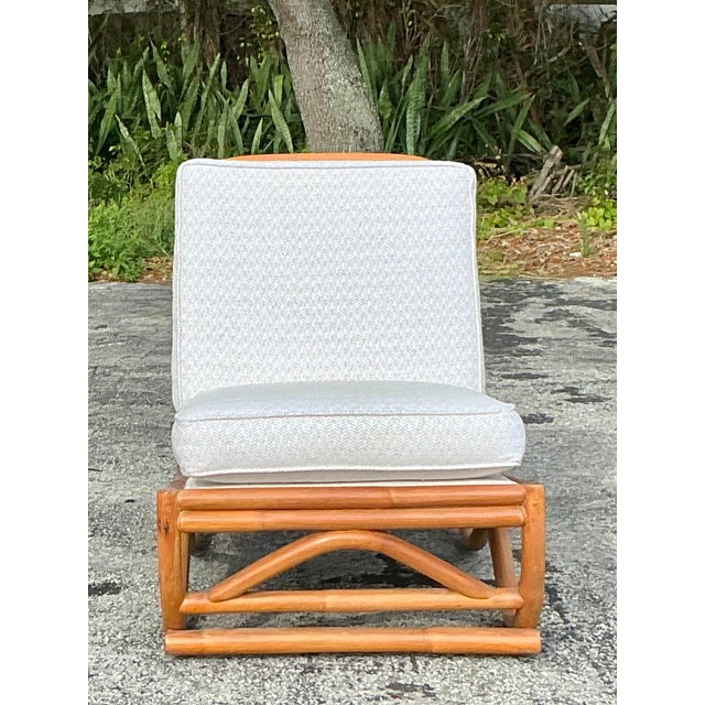 This vintage coastal rattan slipper chair embodies effortless tropical elegance with its beautifully sculptural frame and...