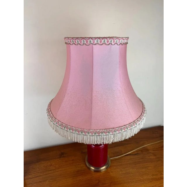 Art Deco style desk lamp with a burgundy red sphere in the center the body is in lacquered iron baques in gilded bronze...