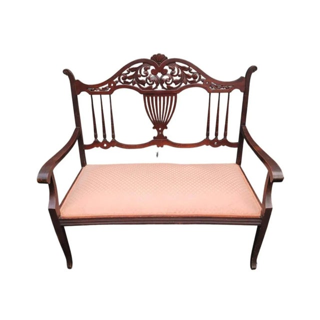 Early 20th Century Regency Carved Mahogany And rose colored Upholstered Settee with very firm seat. It measures 40.75" in...