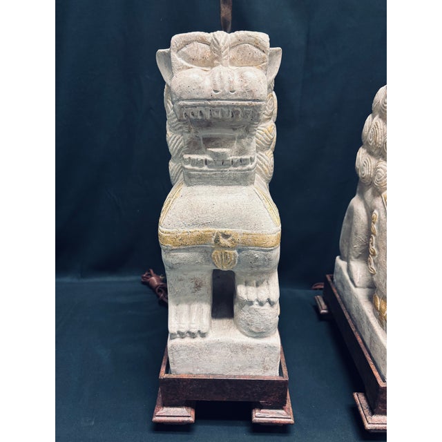 A vintage and very stately pair of Foo Dog lamps enhanced with gold accents. The metal bases are intricately designed...