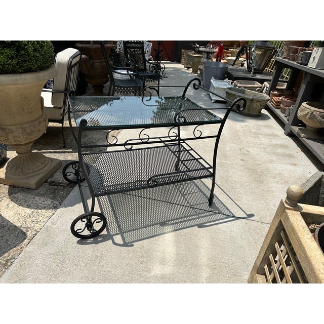 Mid-century modern black bar cart with glass top, perfect for serving drinks on the patio. Has been powder coated to...