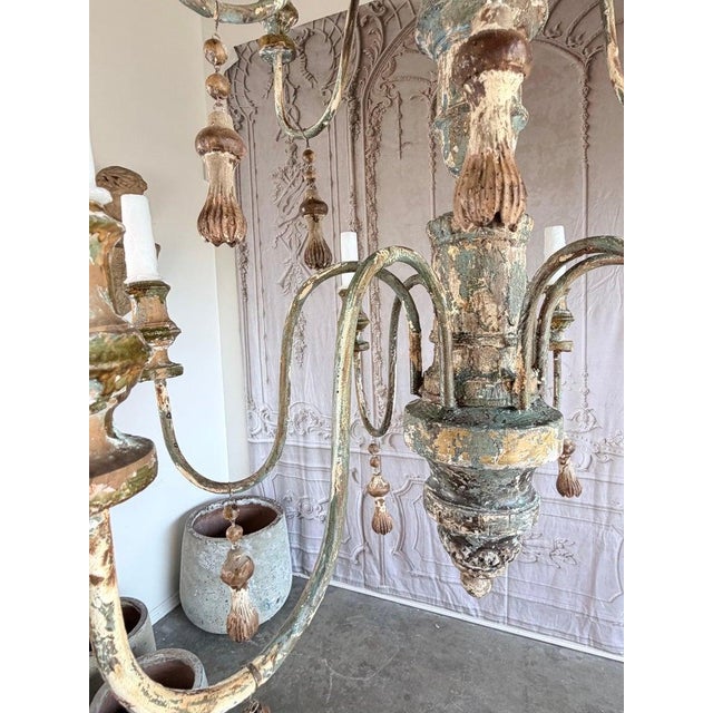 Monumental Italian 12-light chandelier. Hand-carved wood frame with original painted finish in layered tones of sage...