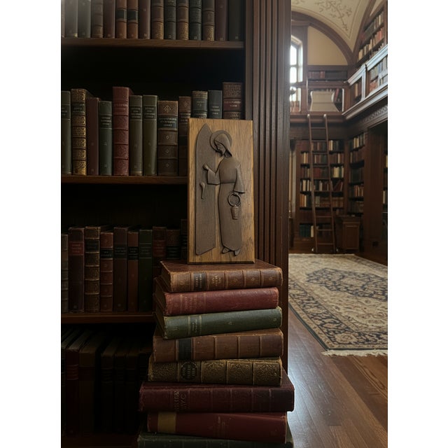 This wooden carving is a religious plaque depicting Jesus Christ knocking at a door, an image often referred to as "The...