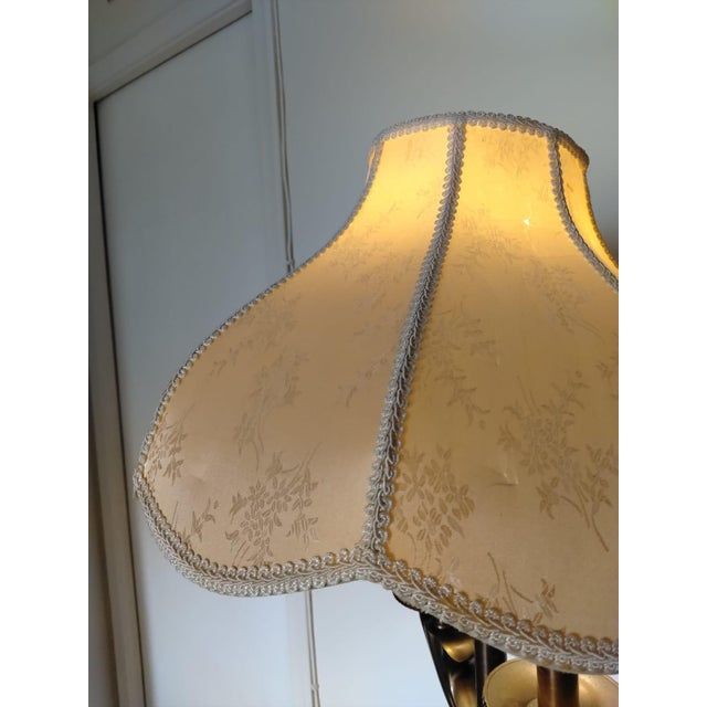 Antique bronze floor lamp with a plastic shade covered in beige linen fabric, beautifully decorated with white flowers and...