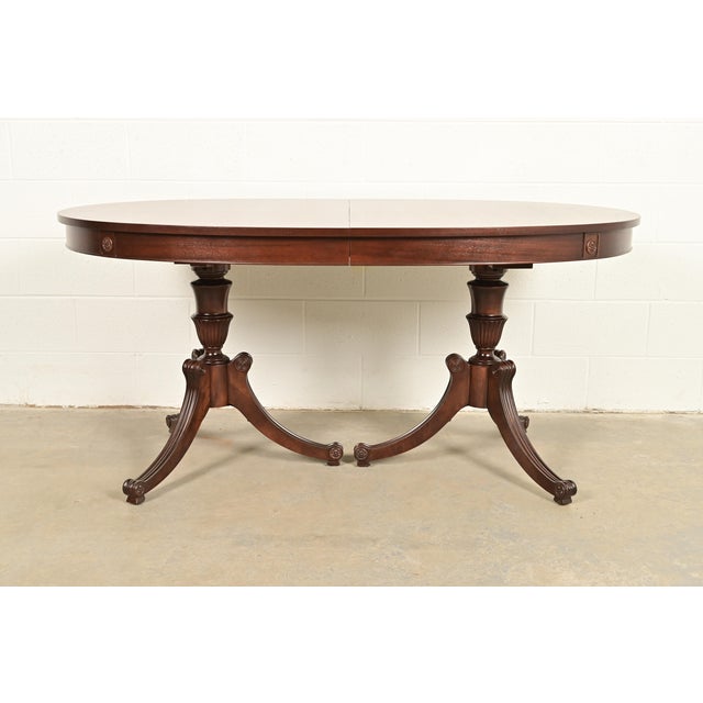 An exceptional Georgian or Regency style double pedestal extension dining table In the manner of Baker Furniture USA,...