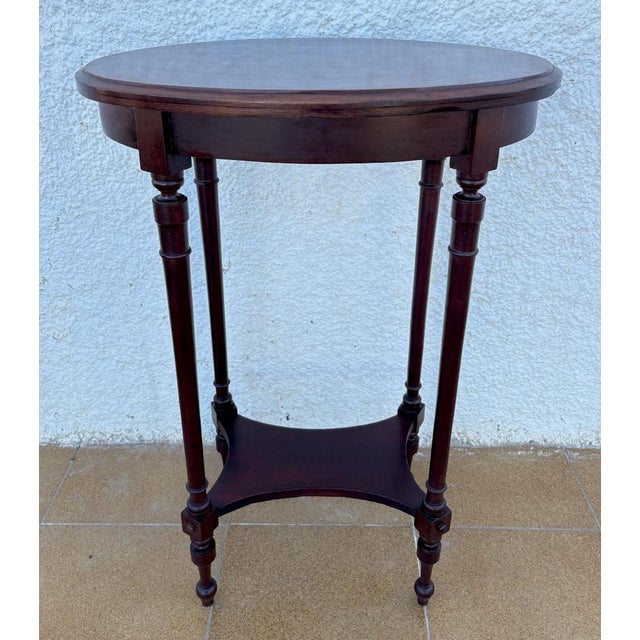 French mid-20th-century oak and wood-topped side table. This antique table from France has an oval top within a wooden...