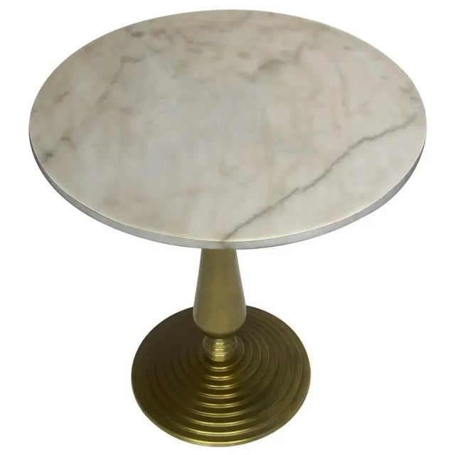 Two elemental materials meet in this quietly dramatic accent table. The base is formed of cast iron with a soft gold...