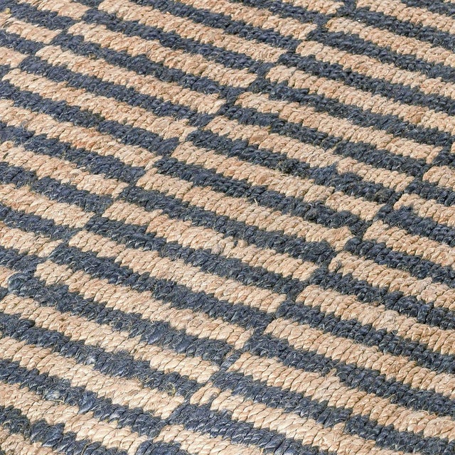 Hand woven jute rug in natural and ocean blue tones. Alternating color pattern creates a rhythmic tile-like effect....