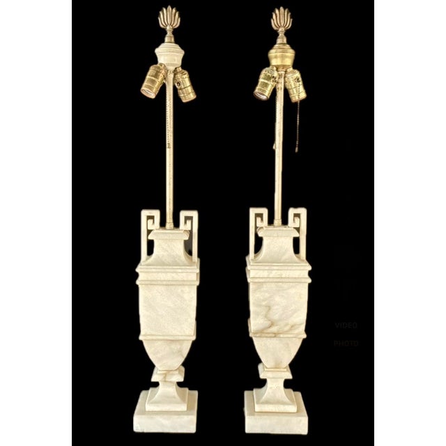 An elegant Pair of Neoclassical Style Alabaster Table Lamps, masterfully carved in a classical urn form and elevated by...