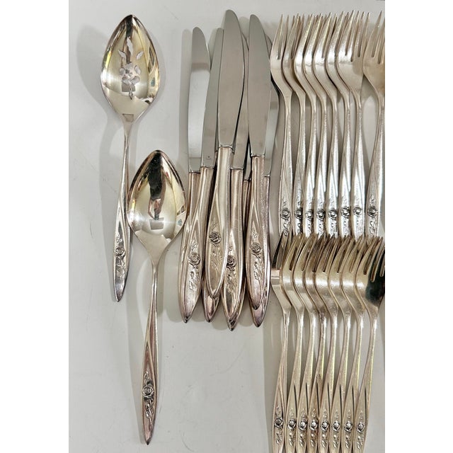 Vintage 52-piece Community silverplate flatware set in the Morning Rose pattern, featuring graceful floral rose detailing...