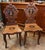 Pair of Black Forest carved walnut hall chairs Features inlaid panels showing medieval hikers, perhaps on some pilgrimage...