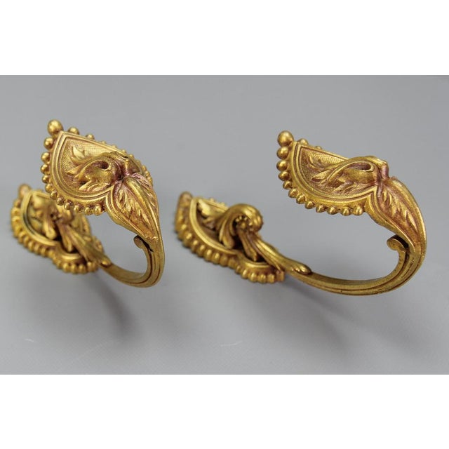 A pair of French neoclassical style bronze curtain tiebacks or curtain holders, from the early 1900s. A beautiful pair of...