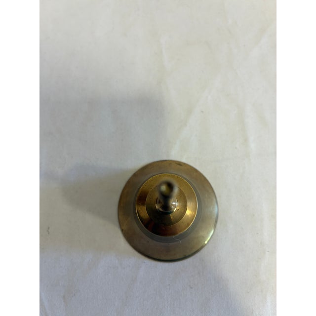 A charming vintage finds solid brass hand bell with a classic bell form, gracefully turned handle, and warm aged patina....