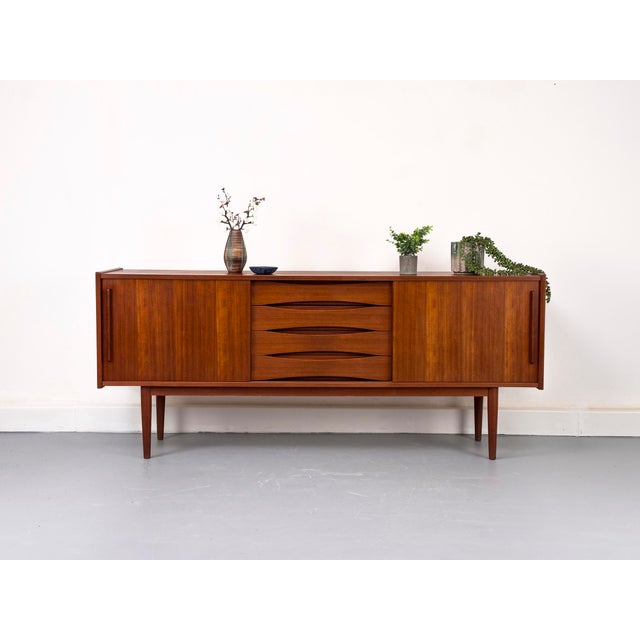 Beautiful sideboard in the style of Arne Vodder. with its two practical sliding doors and four drawers, this sideboard...