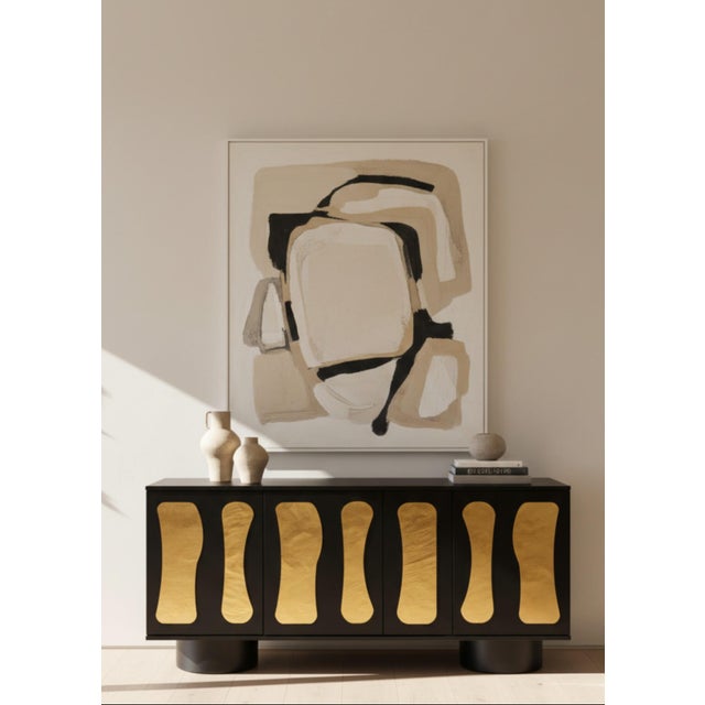 The Charlize Sideboard features a modern, irregular design on the doors with a solid wood black body and matching cylinder...