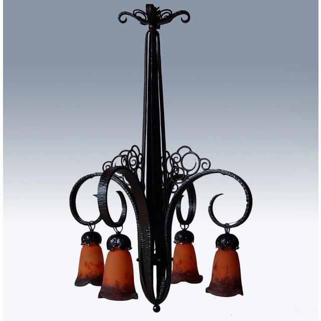 This elegant art deco chandelier from around 1925 was produced by Nics Frères. It has a hammered wrought iron structure...