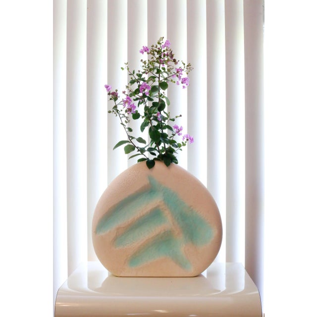 A unique, large-scale postmodern ceramic vase, with a "lava" textured finish, dimensional abstract form, and pink/peach...