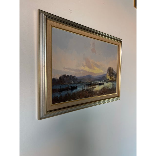 A serene and atmospheric vintage oil painting from the 1980s, this impressionist lake landscape captures a tranquil sunset...