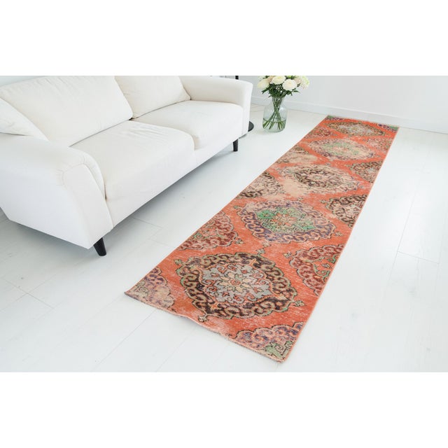 This is a vintage Turkish Oushak rug from the Mid 20th Century. The piece was hand-knotted.