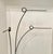 A contemporary abstract metal sculpture featuring hand-formed steel rods rising from a rectangular base. Each element...