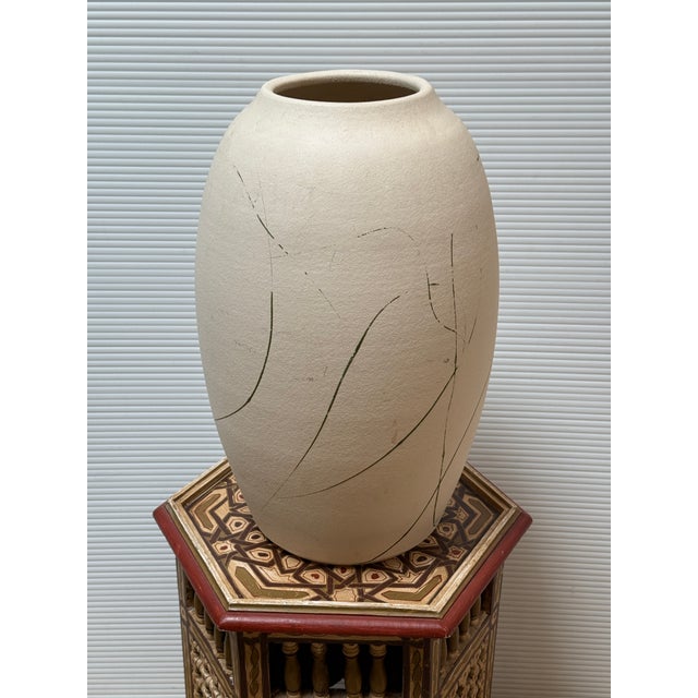 Design Plus Gallery presents an Off White Signed Pottery Vase. This vase is in a fresh white finish with black brush...