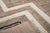 Bold lines, bent at sharp angles, tracing a path across taupe. Two thick ivory bands zigzag downward across a rich taupe...