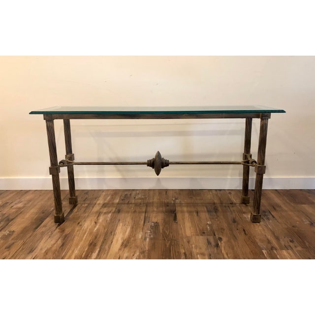 Solidly built metal table with turned legs and embellishments, topped with a thick, beveled, green tinged glass. Made to...