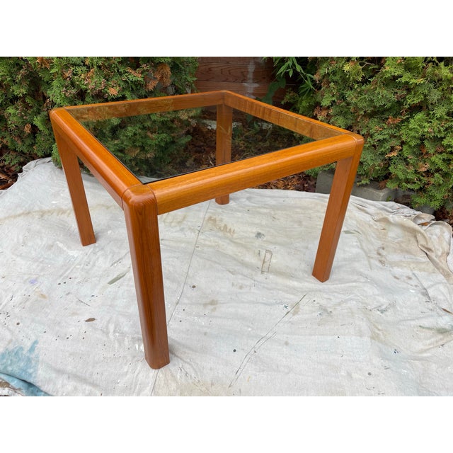 A striking Trioh-Mobler side table, made in Denmark circa the 1960s. Constructed in warm teak with a clear inset glass top...