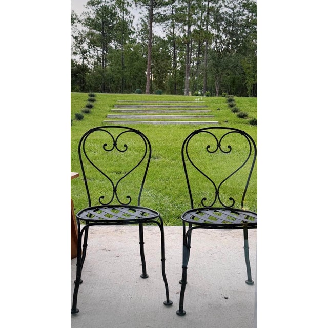 This charming pair of black wrought iron chairs brings a touch of old world character to a dining room, breakfast nook, or...
