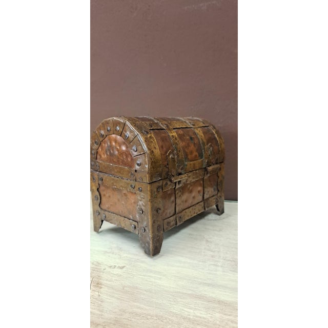 Medieval-style decorative chest or casket, crafted from copper and aged brass with visible rivets. It features a curved...