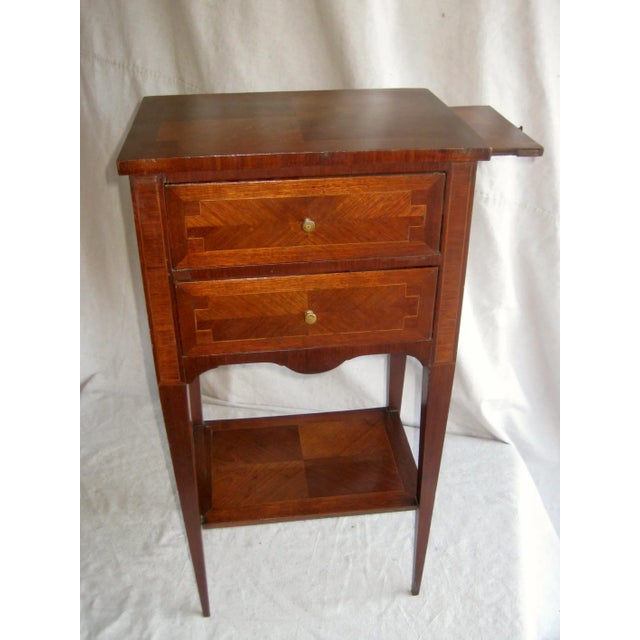 Very lovely and elegant marquetry with the use of color and grain of the wood all over , top , drawers, legs and shelf ....