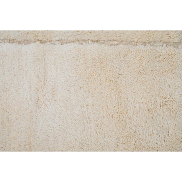 Modern hand-knotted wool rug features a minimalistic grid design in warm Ivory tones. Its plush texture and subtle...