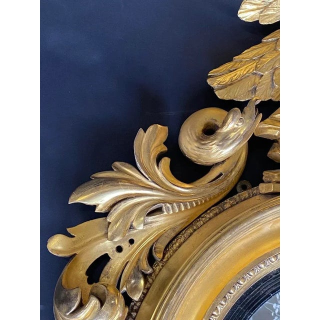 19th Century American Federal gilt wood convex mirror with floral carved details along with a stunning eagle. Dimensions:...