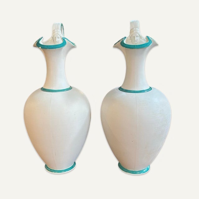 Pair of classical Greek “Oinochoe” wine pitchers. These pitchers are mold-blown with green trim and female faces in...